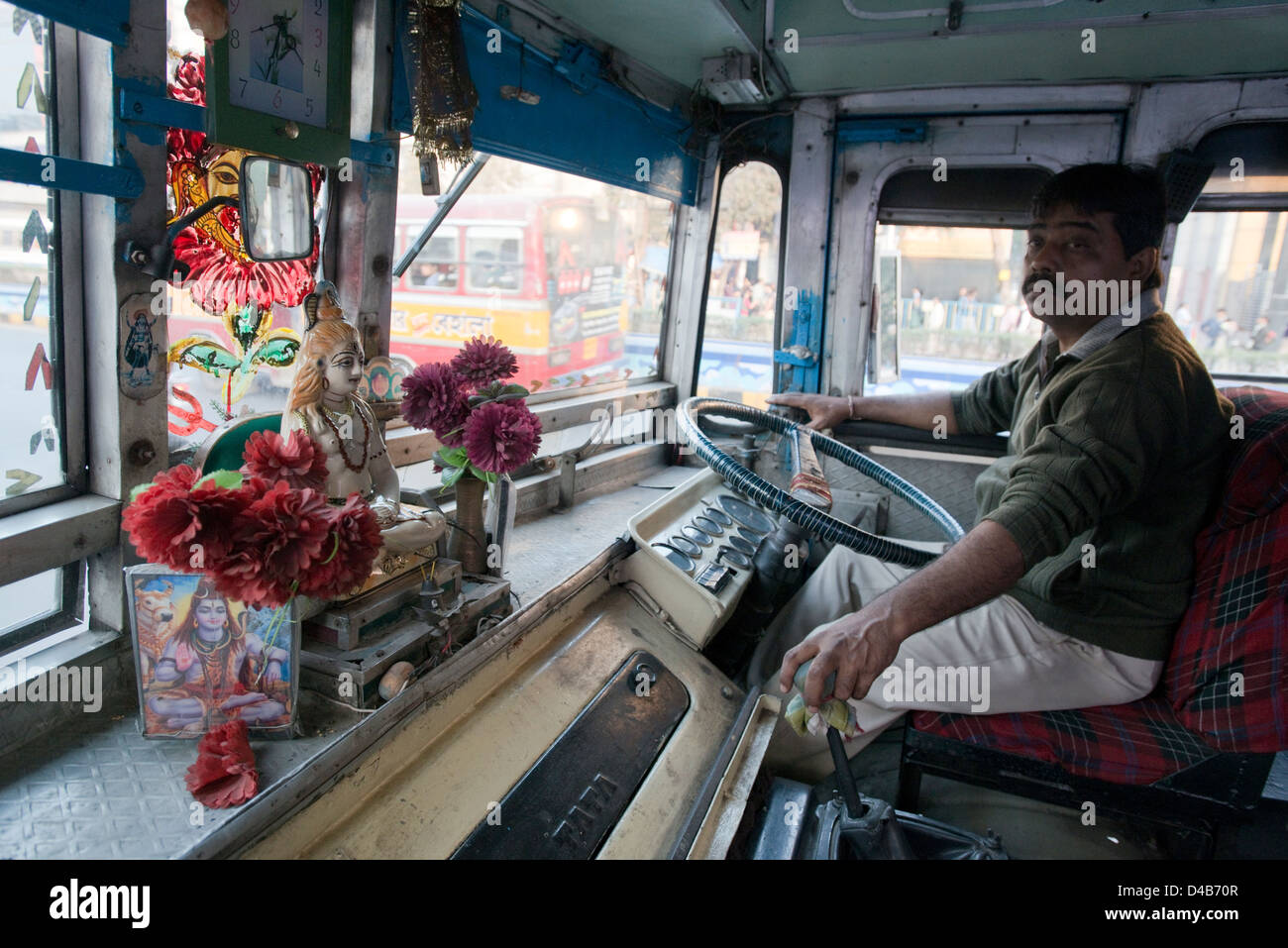 Un santuario al Dio indù Shiva si trova sul cruscotto di un autobus in Kolkata, India Foto Stock