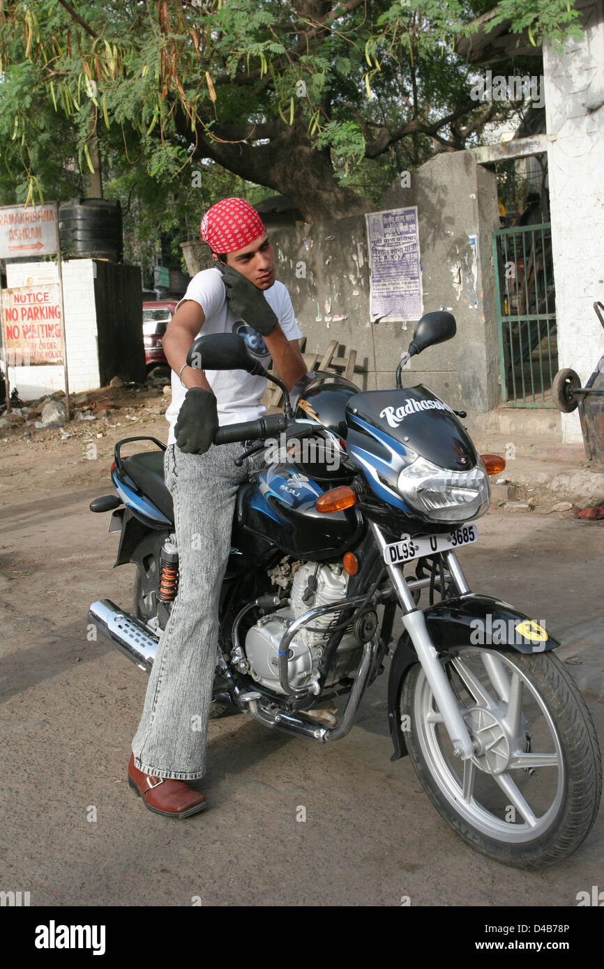 Giovane uomo di Delhi effettua una chiamata sul suo cellulare. Foto Stock