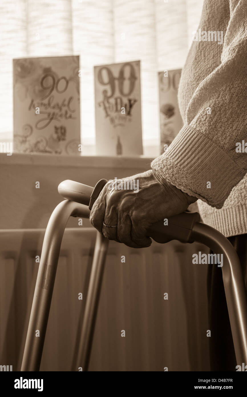 donna di 90 anni vicino alla finestra. Carte di compleanno e radiatore in background.Coronavirus, auto isolamento, distanza sociale, quarantena... concetto Foto Stock