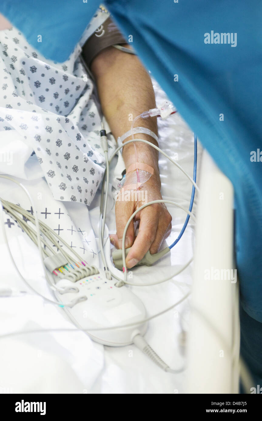 Il paziente ha un gocciolamento endovenoso inserito nel braccio e ossimetro attaccato al dito Foto Stock