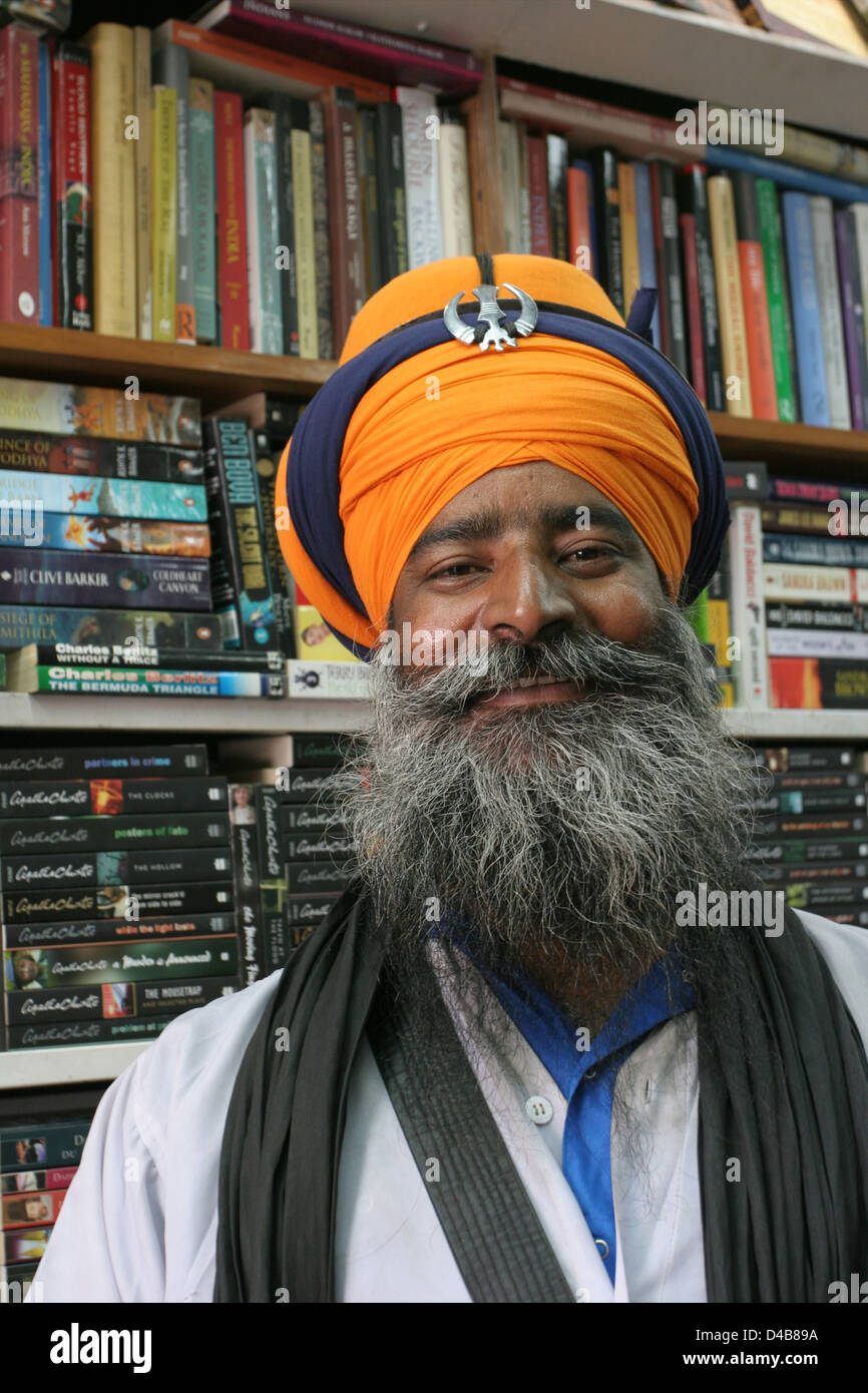 Un guru Sikh coillecting alms in un book shop in New Delhi. Foto Stock