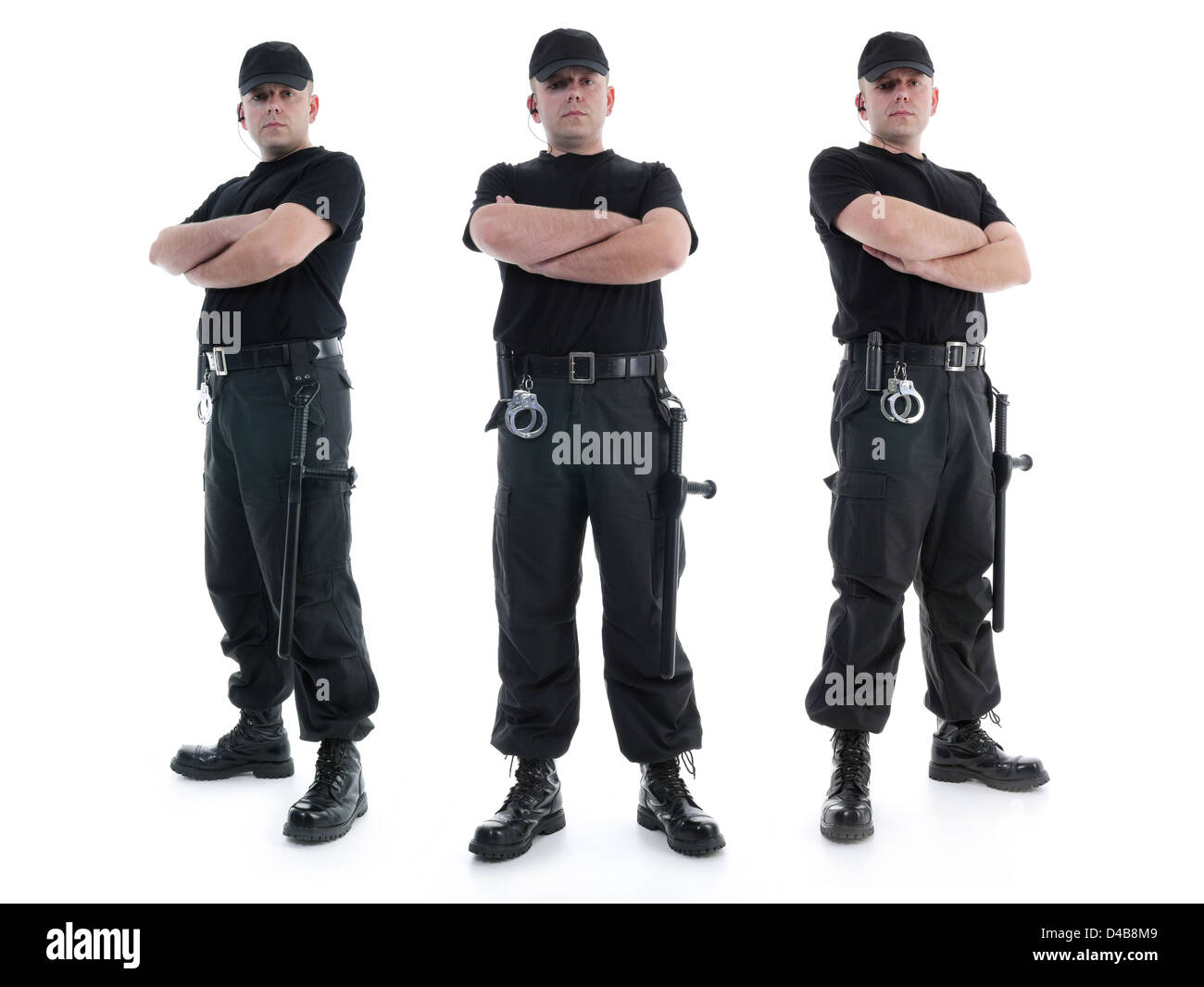 Sicurezza di tre uomini che indossano uniformi di colore nero in dotazione alle forze di polizia locali e manette tranquillamente in piedi con le braccia incrociate Foto Stock