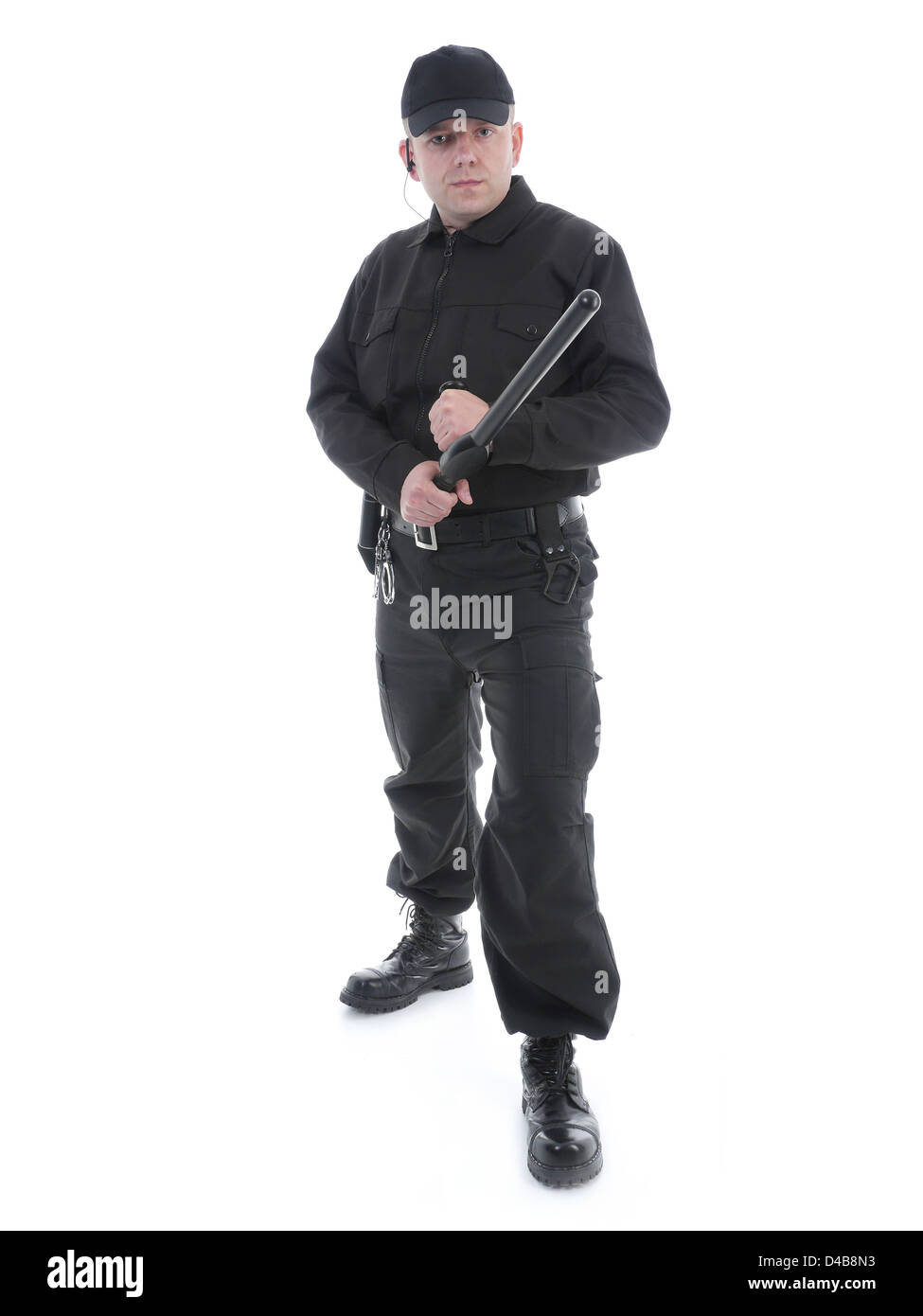 Uomo di polizia vestita di nero uniforme di trattenere fermamente police club in entrambe le mani pronto per l'azione,shot su bianco Foto Stock