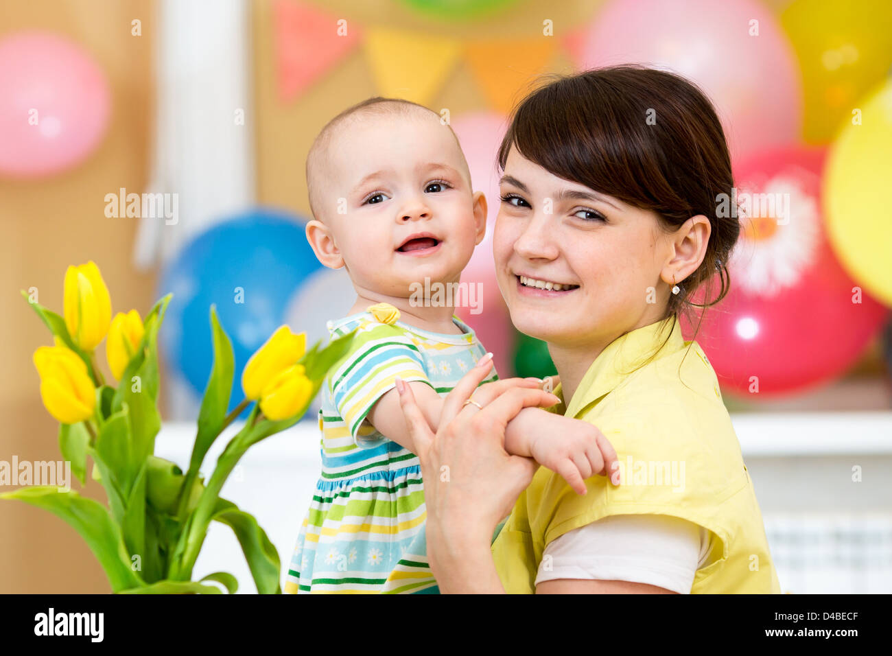 Bambina carina ragazza con la madre su sfondo di festa Foto Stock