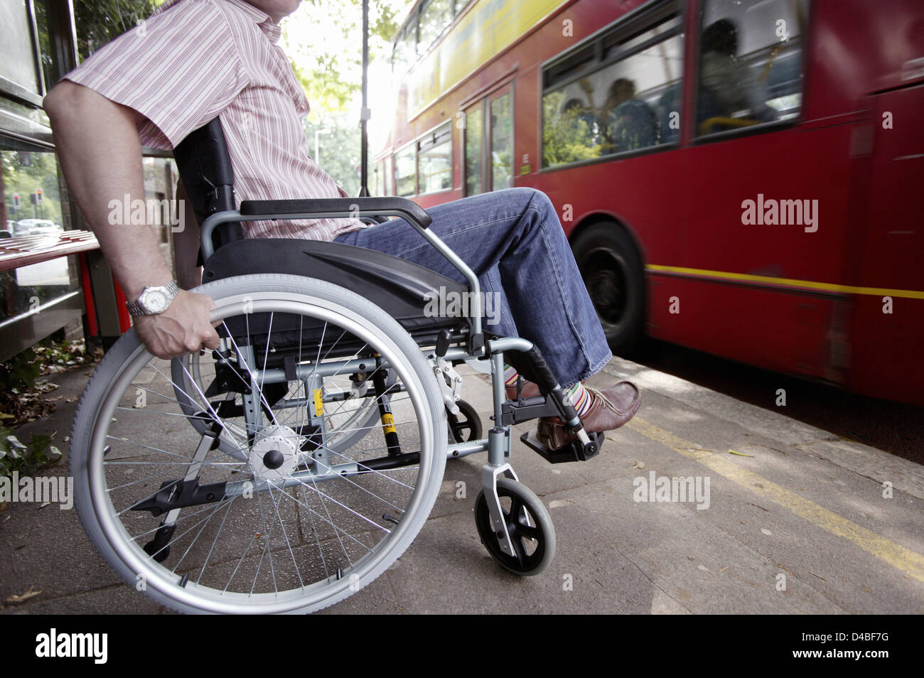 Inghilterra, Londra, uomo disabili in sedia a rotelle presso la fermata degli autobus Foto Stock