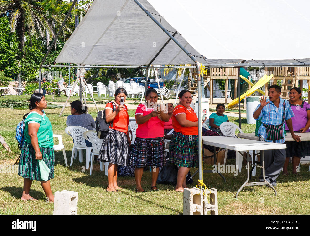 Molte donne in Belize nel parco, alcuni di loro di prendere immagini di telefono cellulare Foto Stock