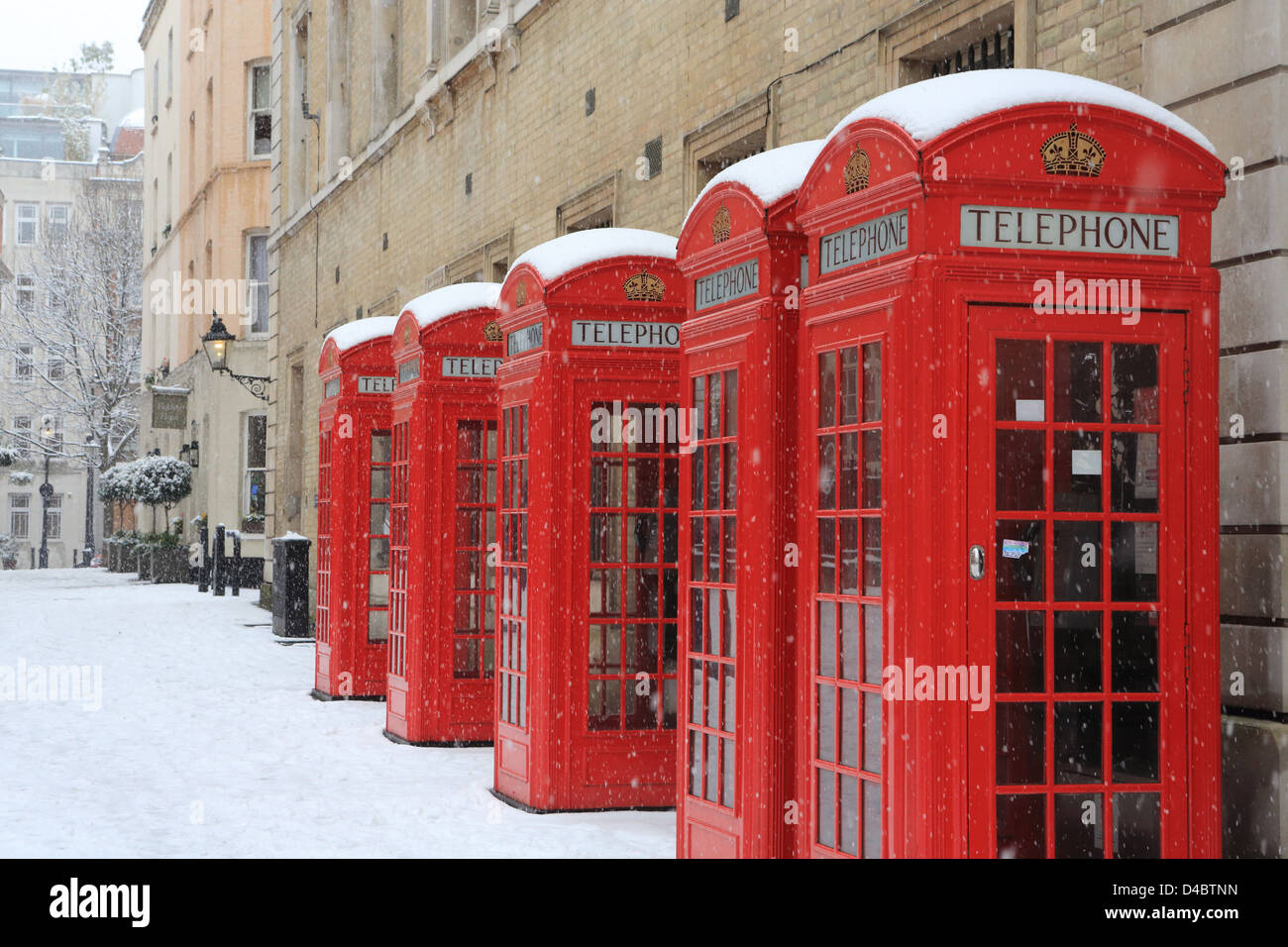 Telefono rosso scatole in Broad Street, Off Bow Street, Covent Garden di Londra, nella neve, in inverno, in Inghilterra, Regno Unito Foto Stock