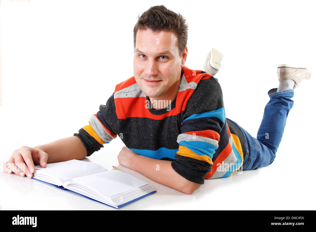 Giovane uomo la lettura o lo studio sul pavimento a piena lunghezza isolato su bianco Foto Stock