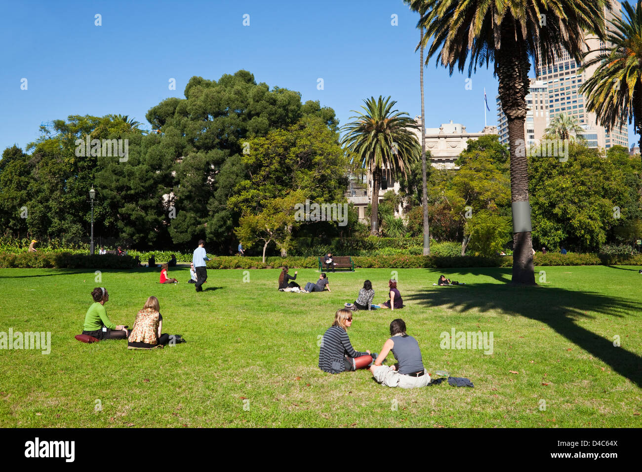 I lavoratori della città rilassarsi sul prato di giardini Carlton. Fitzroy, Melbourne, Victoria, Australia Foto Stock