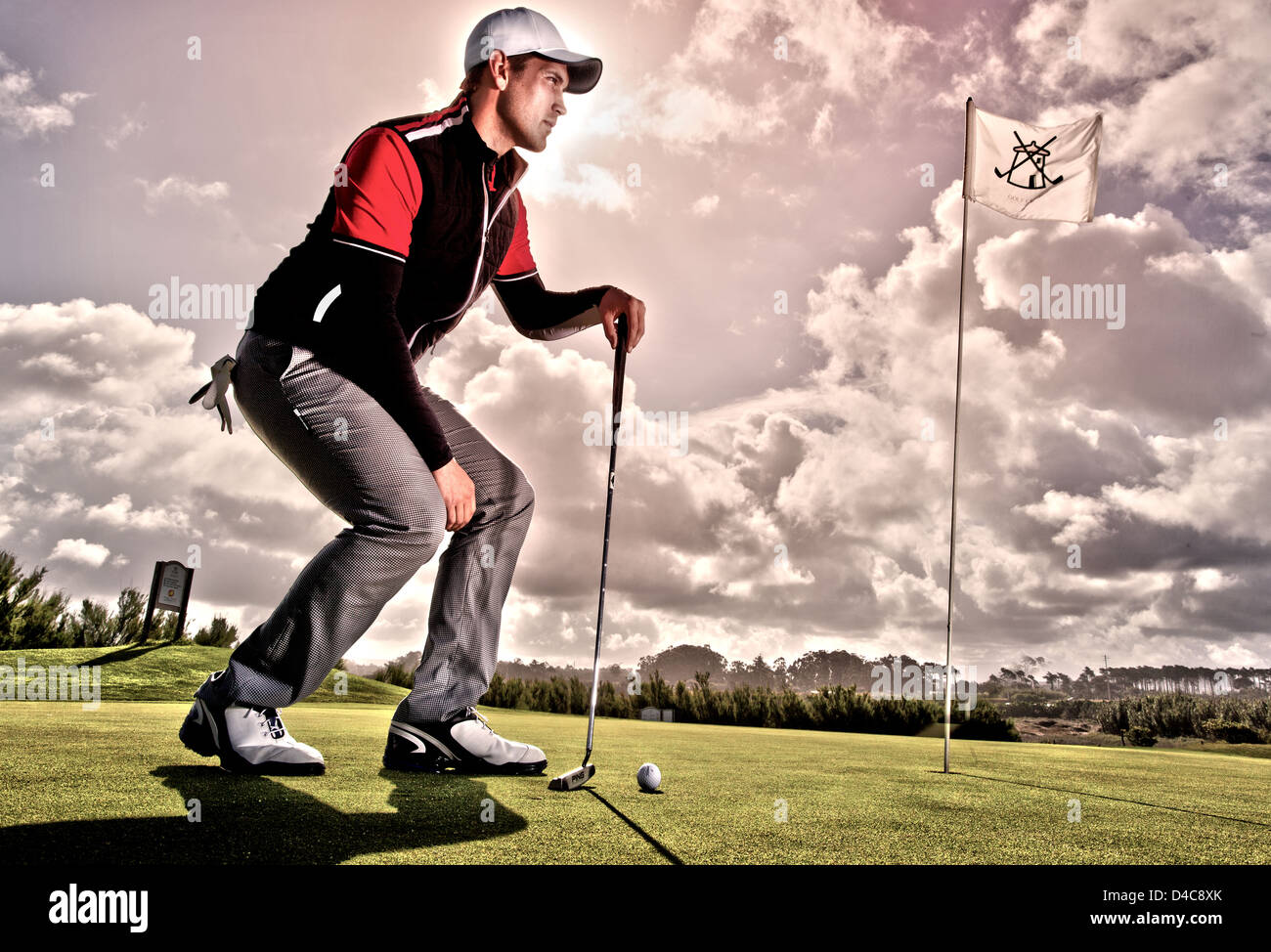 Un Europeo di età maschio 20-25 giocando a golf sotto la pioggia Foto Stock