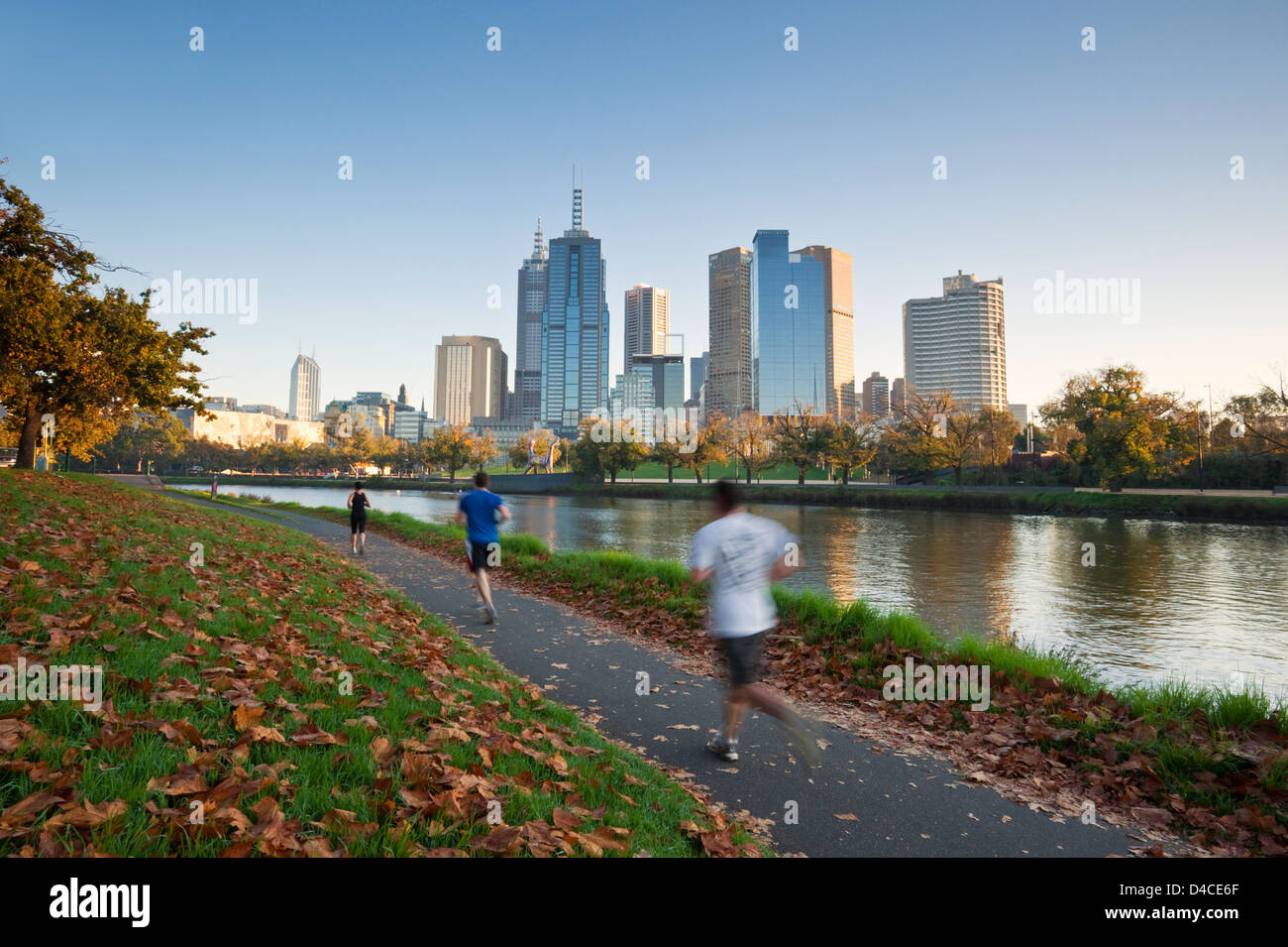 Jogging sulle rive del Fiume Yarra con lo skyline della città in background. Melbourne, Victoria, Australia Foto Stock