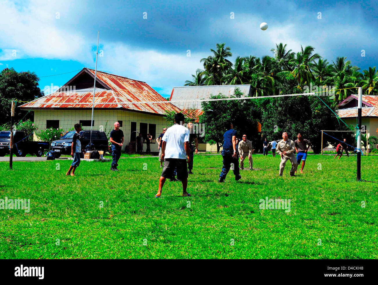 Il suo equipaggio giocare a pallavolo con bambini indonesiano Foto Stock