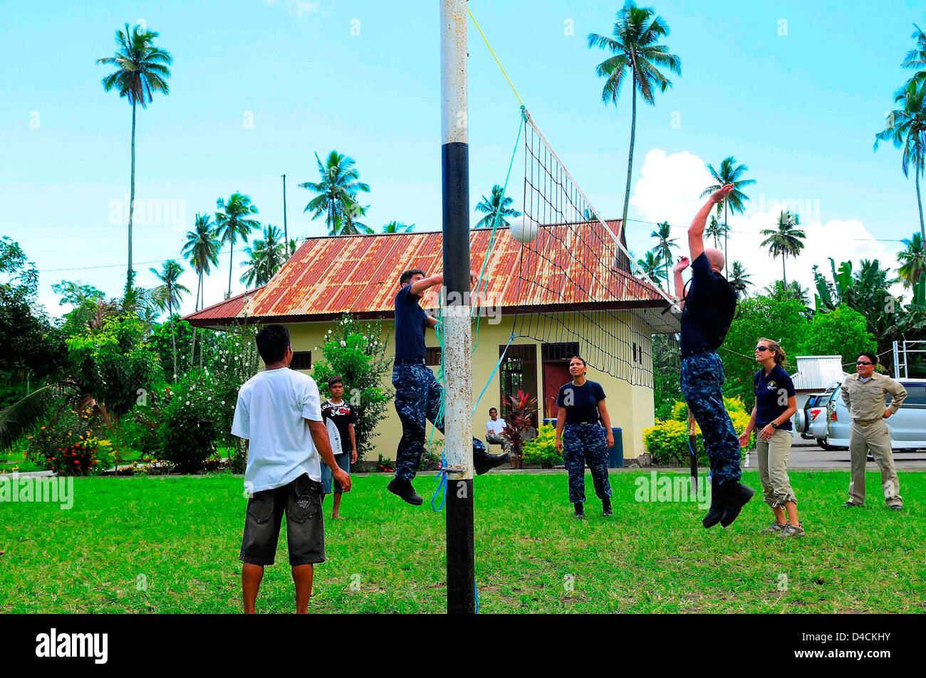 Il suo equipaggio giocare a pallavolo con bambini indonesiano Foto Stock