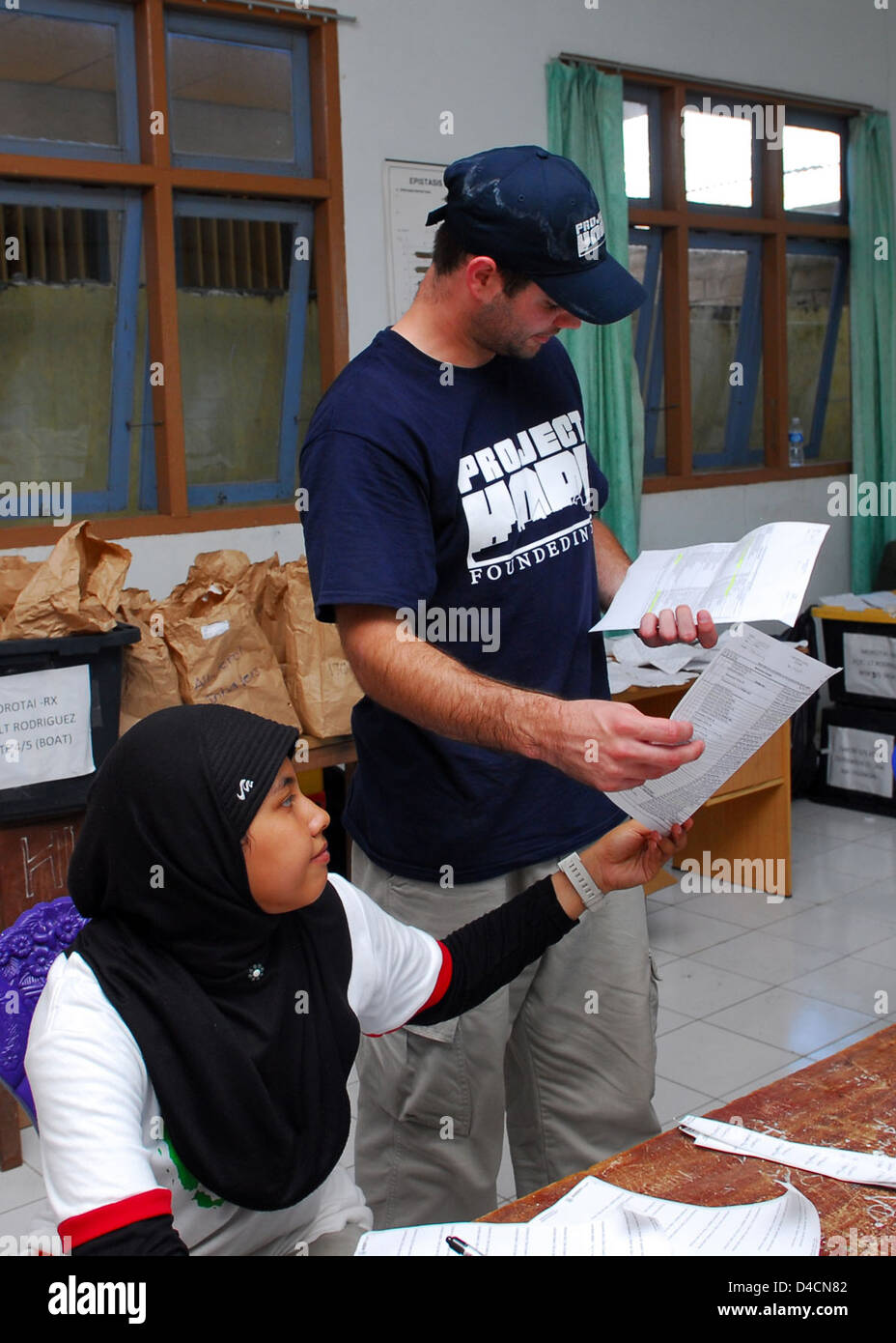 Un Progetto Speranza volontario medico professionista e la nazione ospitante il farmacista rivedere un elenco di prescrizioni Foto Stock