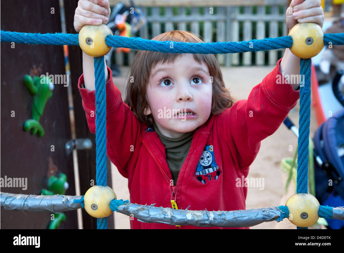 4 anno vecchio ragazzo sulla fune di telaio di arrampicata Foto Stock