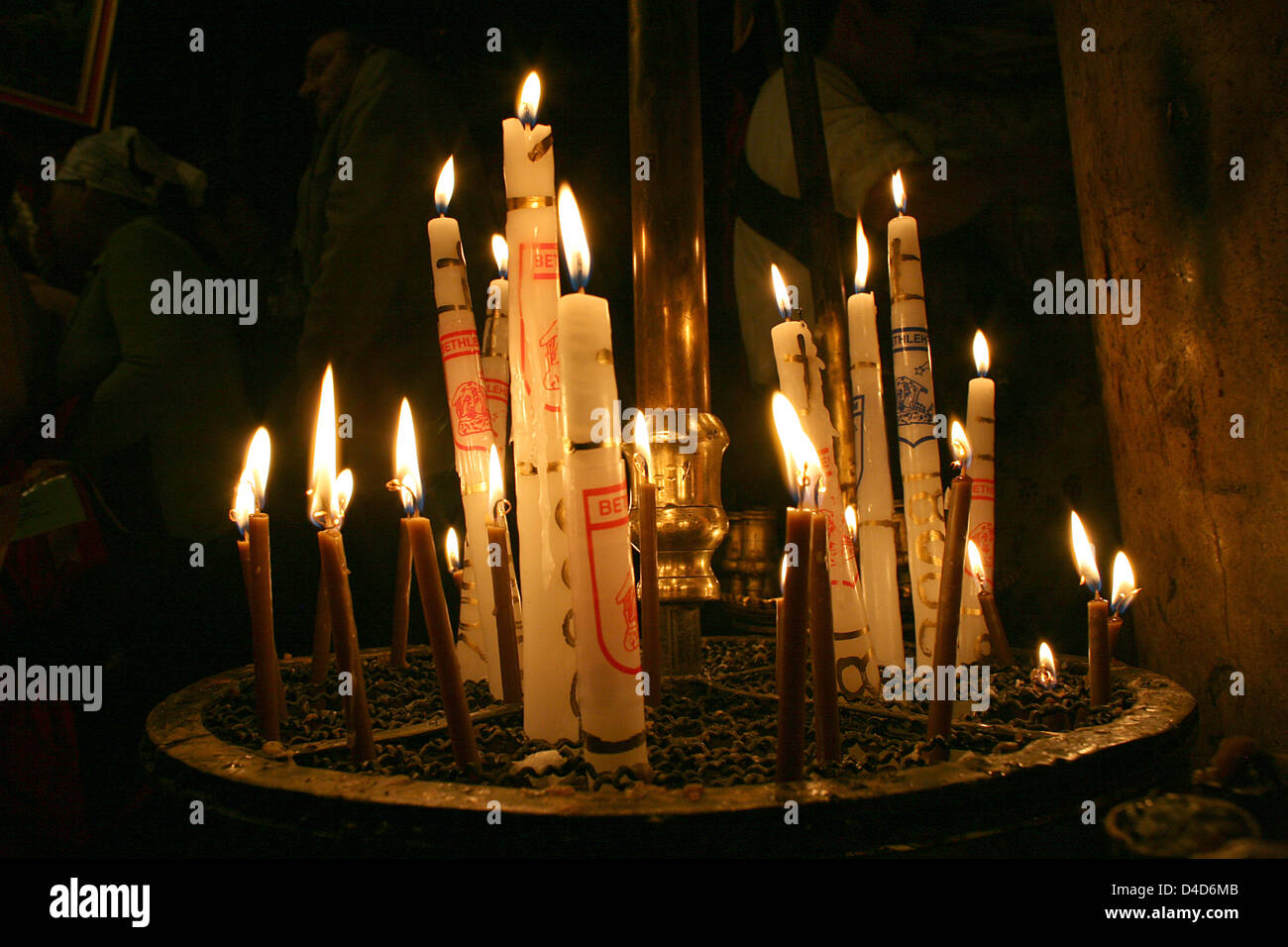 Candele bruciano davanti alla nascita di nicchia in chiesa della Natività, Betlehem, Territori palestinesi, 28 febbraio 2008. Una stella d'argento, sotto l'altare nella grotta della Natività, segna il punto creduto per essere il luogo di nascita di Gesù. Foto: Rainer Jensen Foto Stock