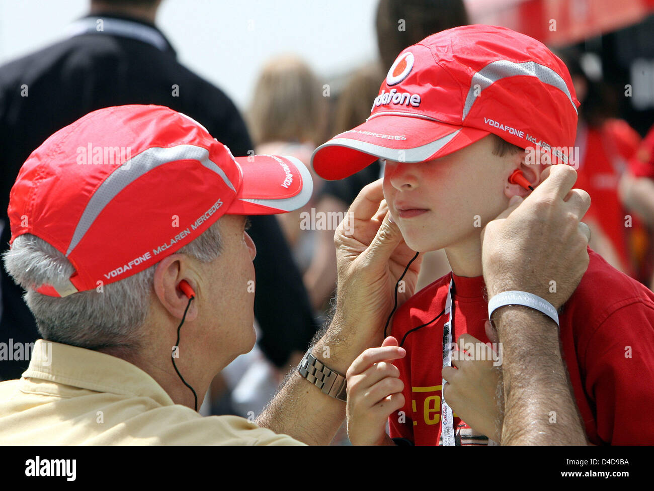 Una F1 Ventola regola i tappi per le orecchie di un bambino prima della  sessione di prove libere sul circuito di Sakhir vicino a Manama, Bahrein,  05 aprile 2008. Il Gran Premio