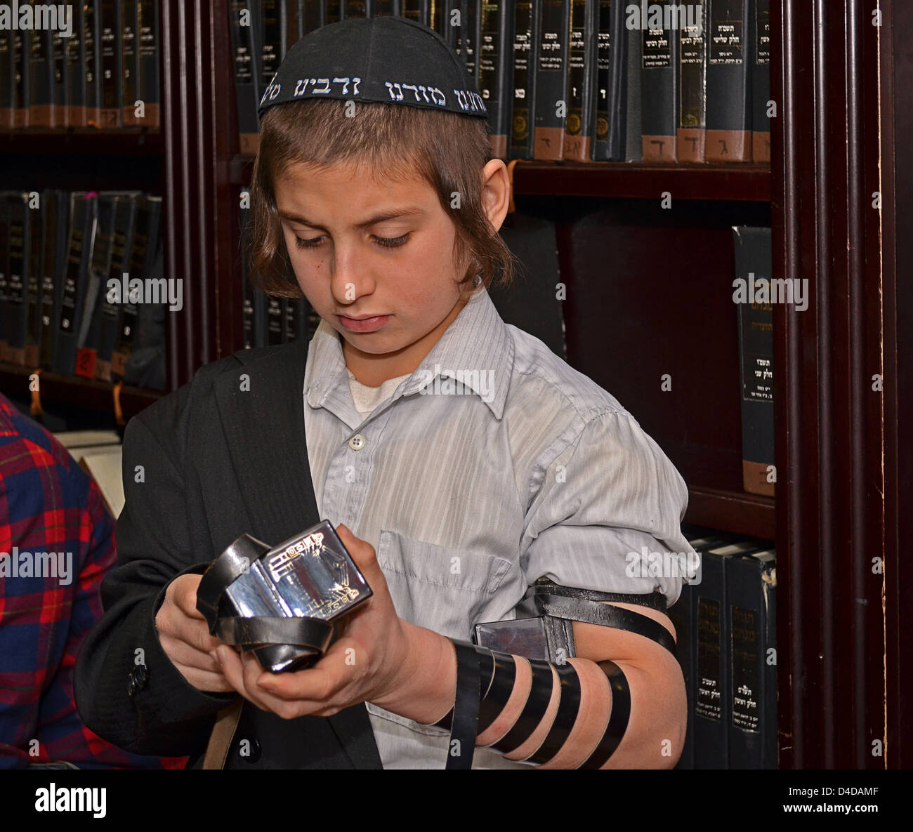 1religiosa ebraica boy età 12 anni e 10 mesi si prepara per il bar mitzvà e mettendo su Teffilin Foto Stock