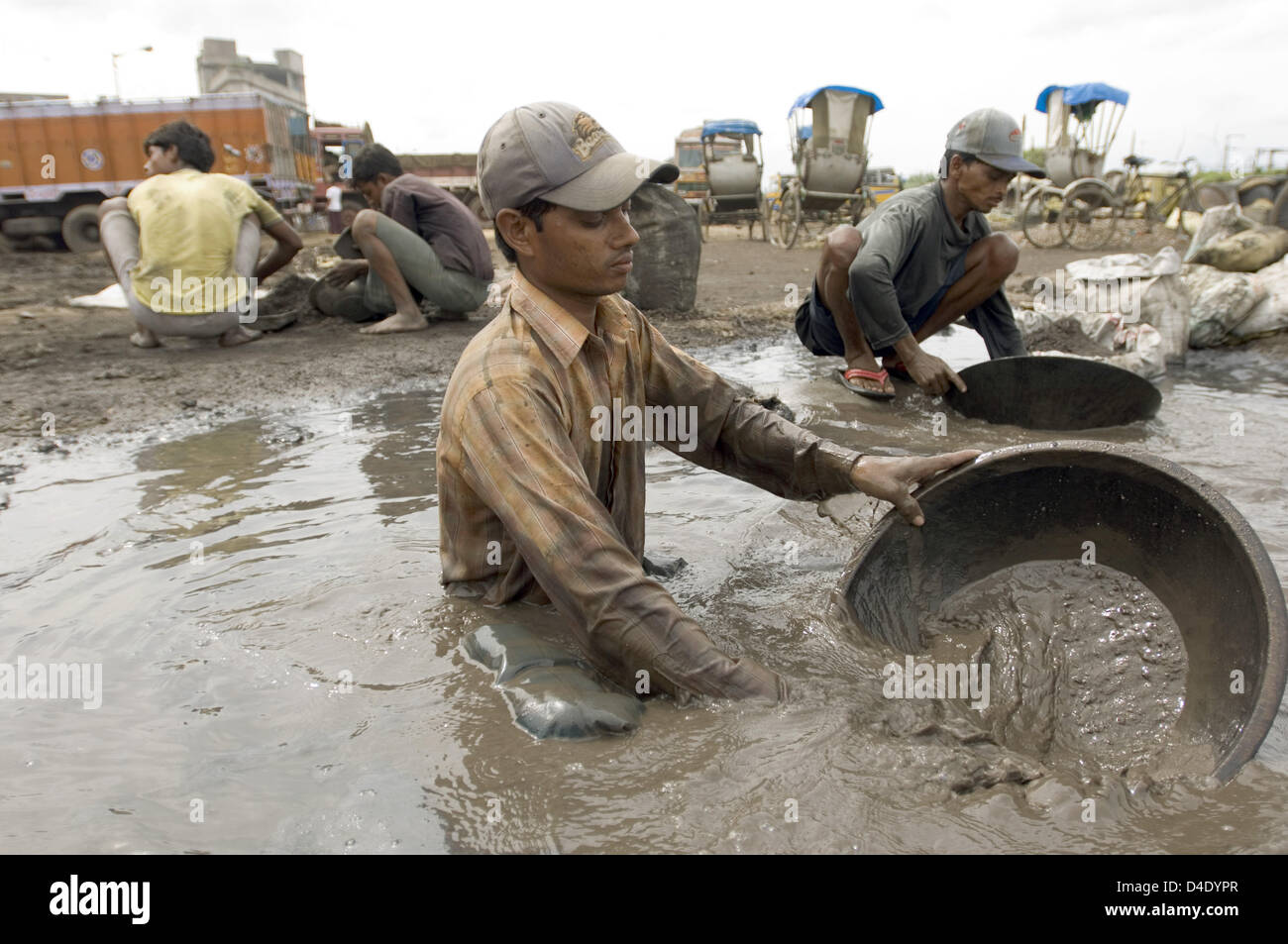 (Dpa) file il file immagine datata luglio/agosto 2007 mostra gli abitanti degli slum rendendo loro la vita dal riciclaggio dei rifiuti industriali in quella di Howrah, India. Per la ricerca di residui di metallo, il giorno operai wash out tossici scorie industriali tra l'odore di carbone e di zolfo dei vapori dal bagno fuso sospeso in aria. Foto: Denis Meyer Foto Stock