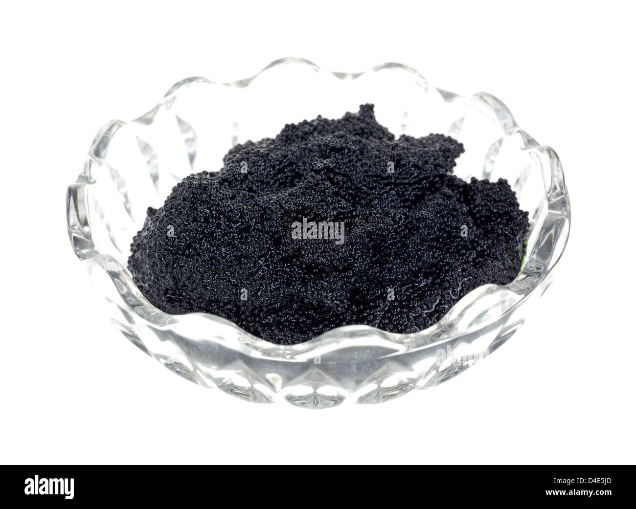 Un piccolo ornati in recipiente di vetro riempito con caviale nero su uno sfondo bianco. Foto Stock