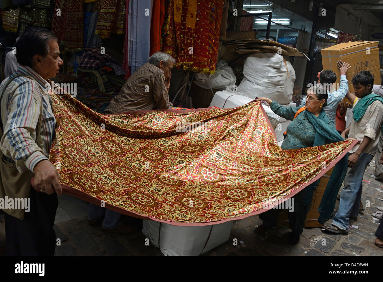Una coppia in cerca di qualche materiale per la realizzazione di un sari nel mercato Fetehpuri, Chandni Chowk, Vecchia Delhi, India Foto Stock