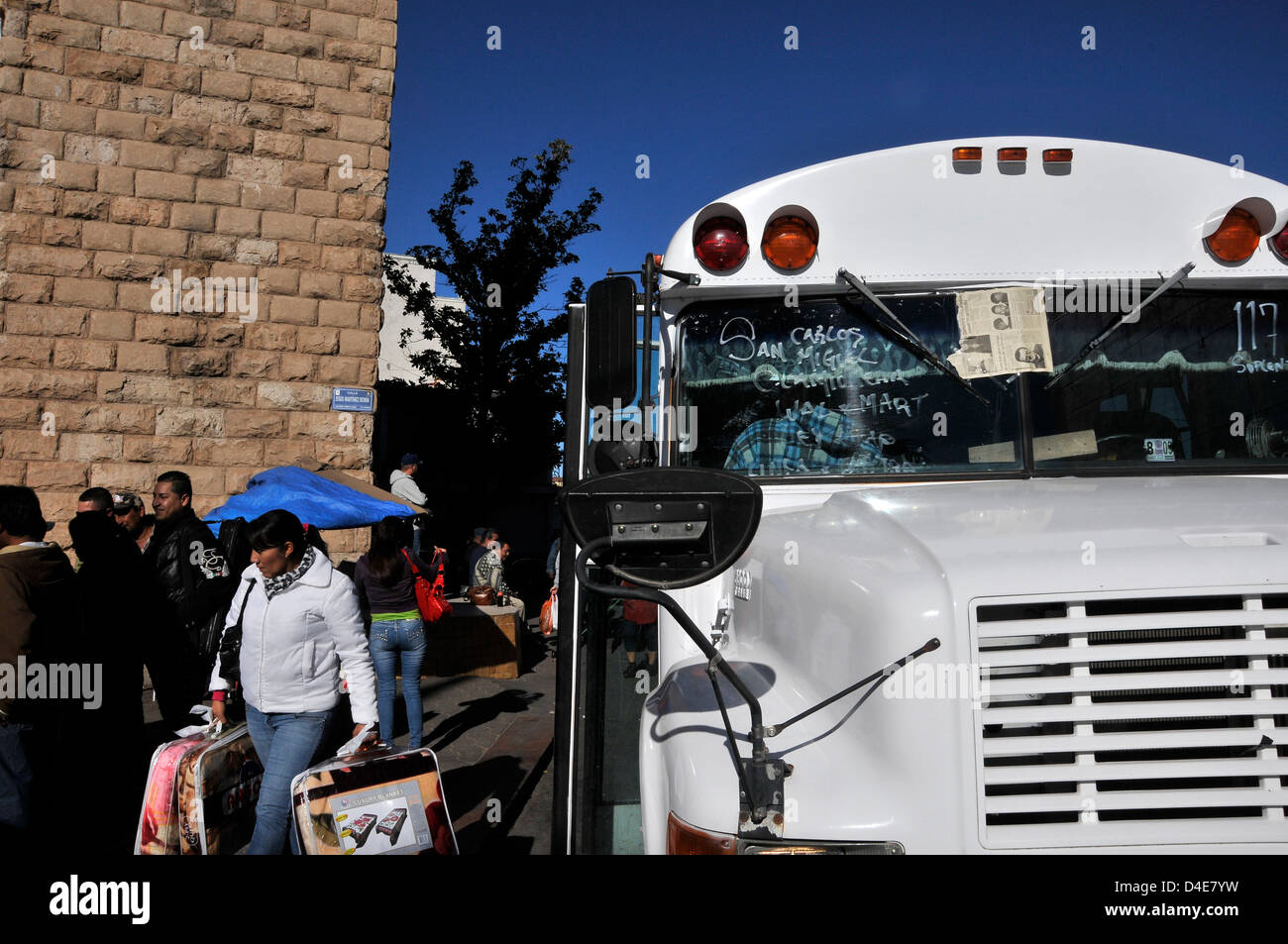 Una donna con le borse della spesa esce un bus a Plaza nel quartiere business di Nogales, Sonora, Messico. Foto Stock