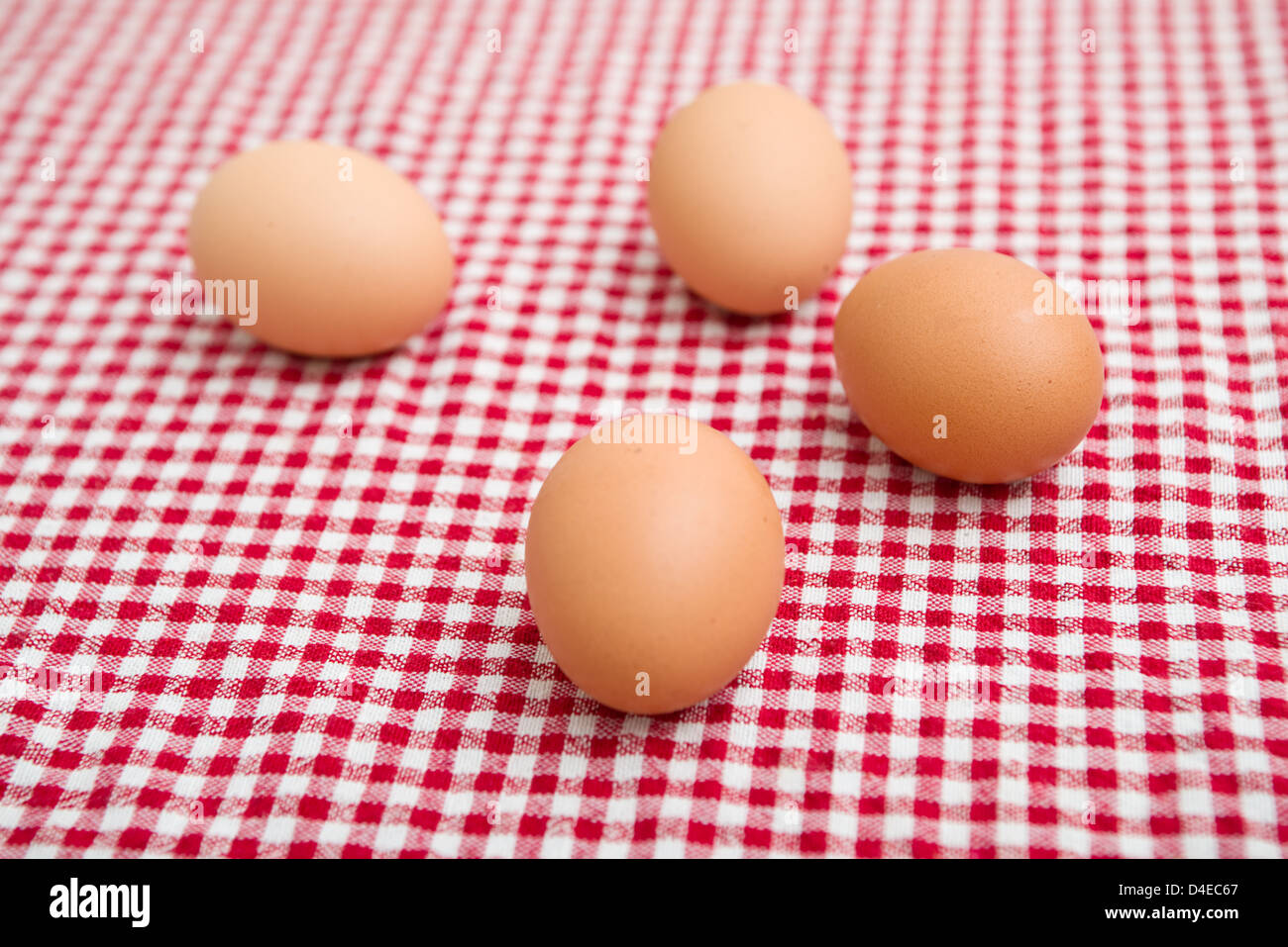 Uova di gallina sul tavolo con il rosso e bianco tovaglia a scacchi. Foto Stock