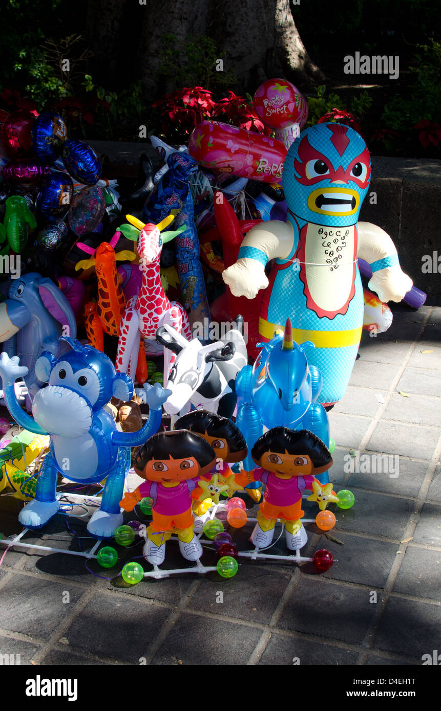 Un venditore ambulante di mercanzia gonfiabile nel Zocalo, Oaxaca, Messico. Foto Stock