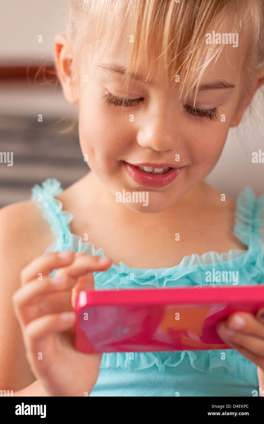 Bambina gioca con uno smartphone Foto Stock