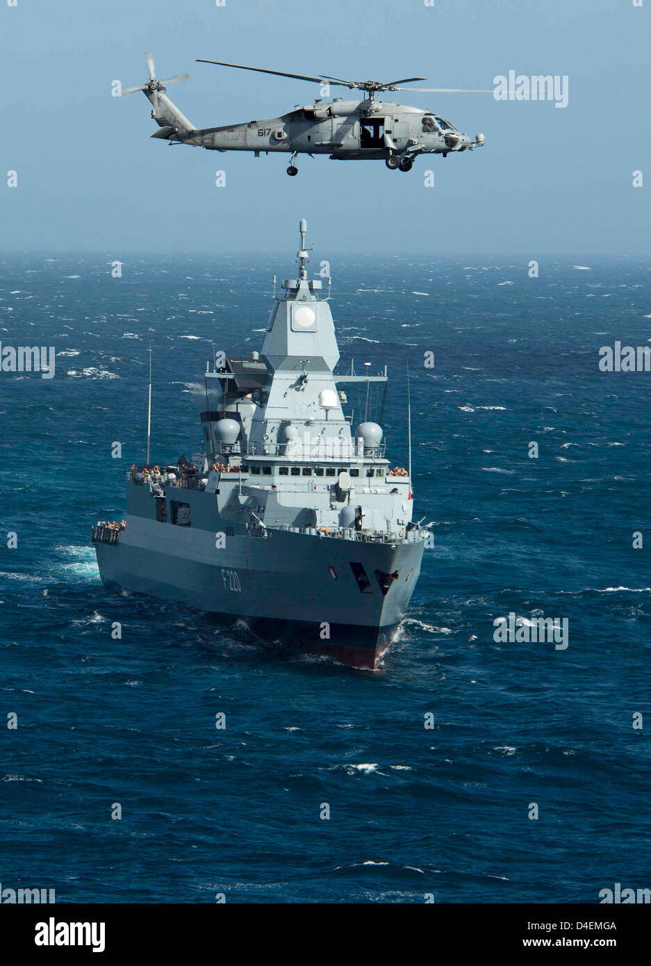 Un US Navy HH-60H Sea Hawk elicottero sorvola la marina militare tedesca frigate FGS Amburgo come esso transita il Mare Mediterraneo con il Dwight D. Eisenhower Carrier Strike gruppo Marzo 11, 2013. Foto Stock