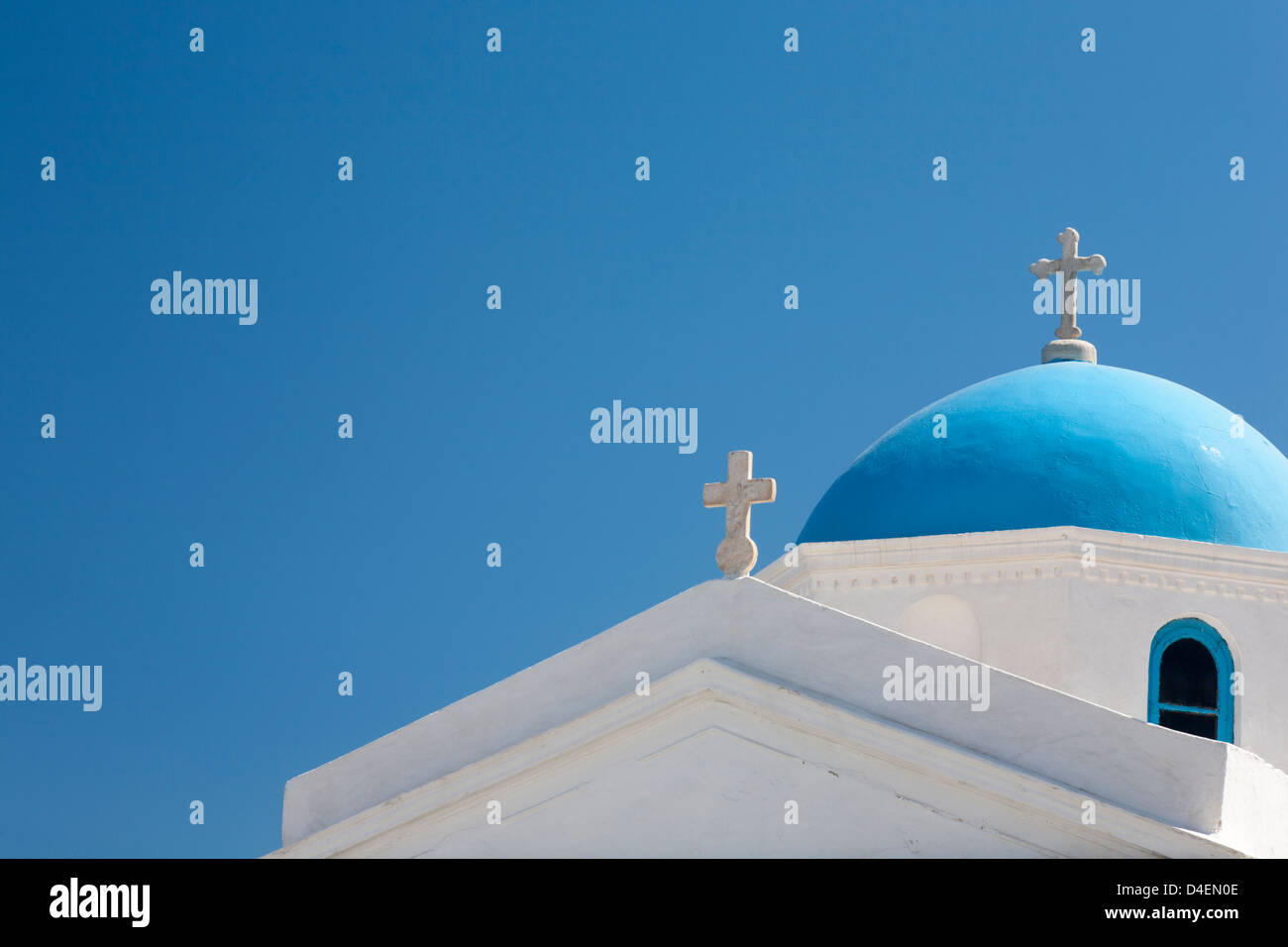 Croci bianche sulla chiesa greco-ortodossa con cupola blu sotto il cielo azzurro dell'isola di Mykonos in Grecia Foto Stock
