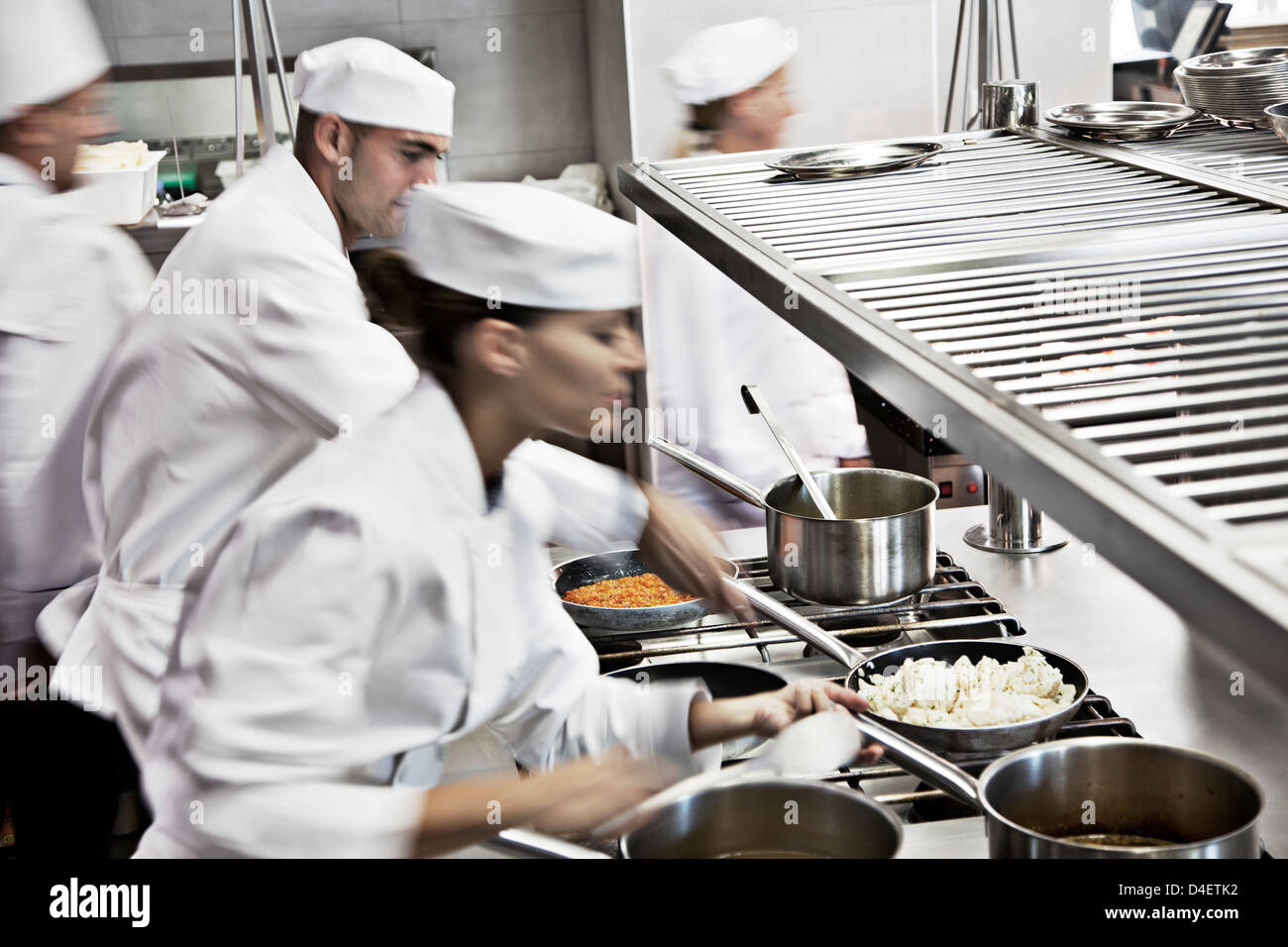 Gli chef cucinare nel ristorante cucina Foto Stock