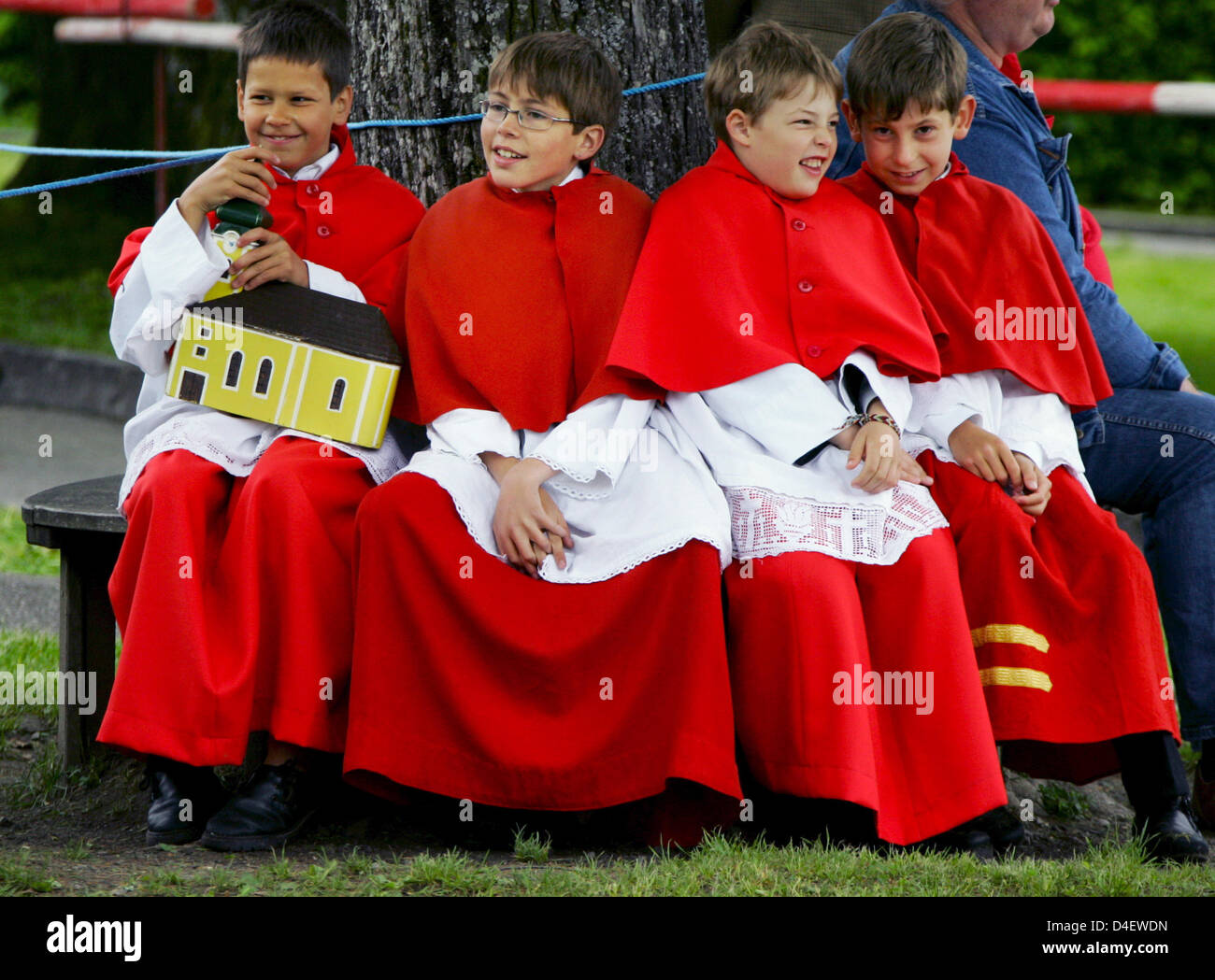 Ministrants sedersi sotto un albero durante il Corpus Christi festa processione sul lago di 'Staffelsee' nei pressi di Seehausen, Germania, 22 maggio 2008. Cattolici celebrano la festa in onore della santa Eucaristia. Dopo la sua visione della monaca agostiniana nel 1264, Papa Urbano IV dichiarò il Corpus Christi festa celebrata il secondo giovedì dopo la Pentecoste. Foto: MATTHIAS SCHRADER Foto Stock