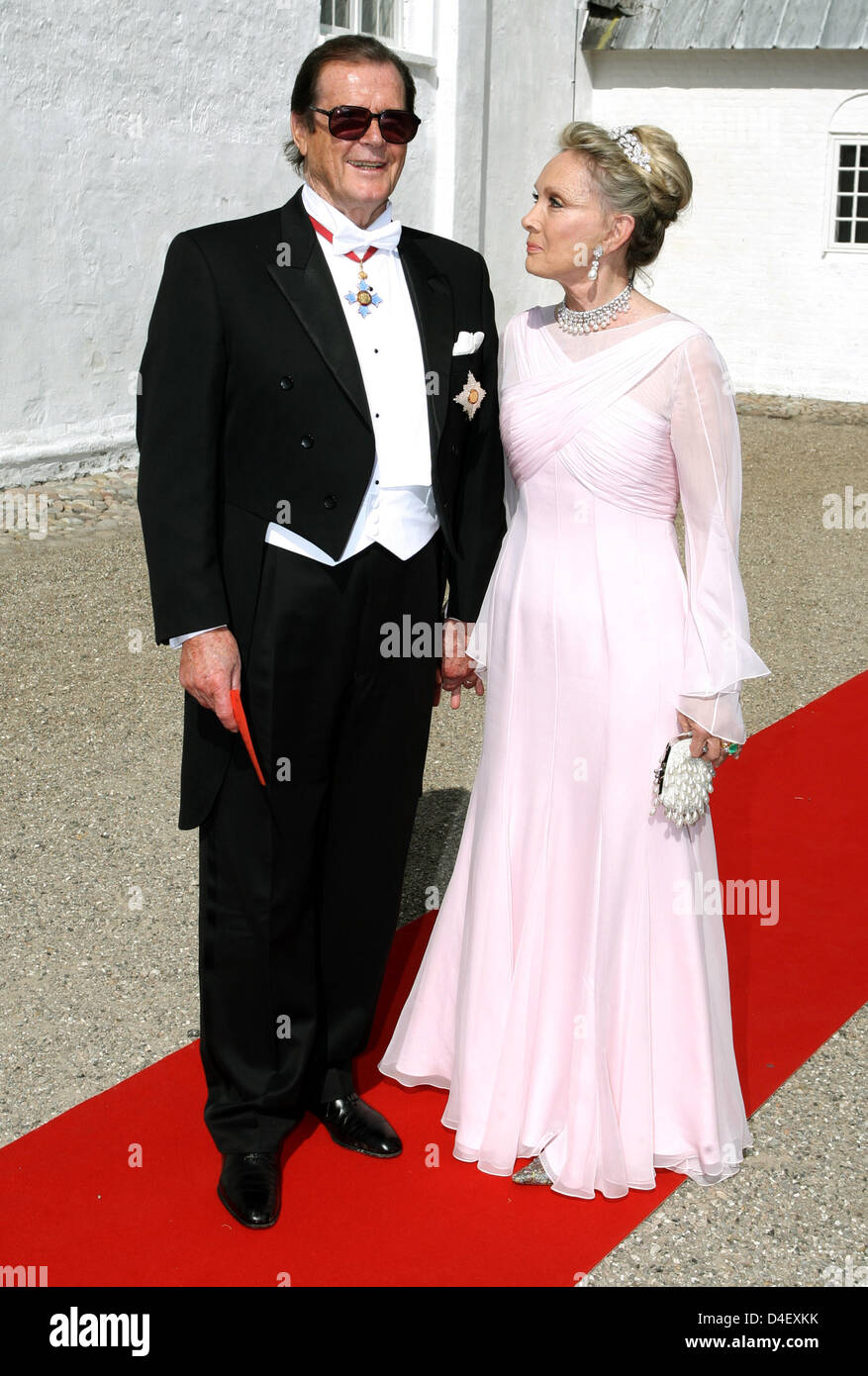 Attore Roger Moore e sua moglie Christina Tholstrup arrivare per le nozze del principe Joachim e la principessa Marie Cavallier presso la chiesa a Mogeltonder, Danimarca, il 24 maggio 2008. Foto: Kay Nietfeld Foto Stock