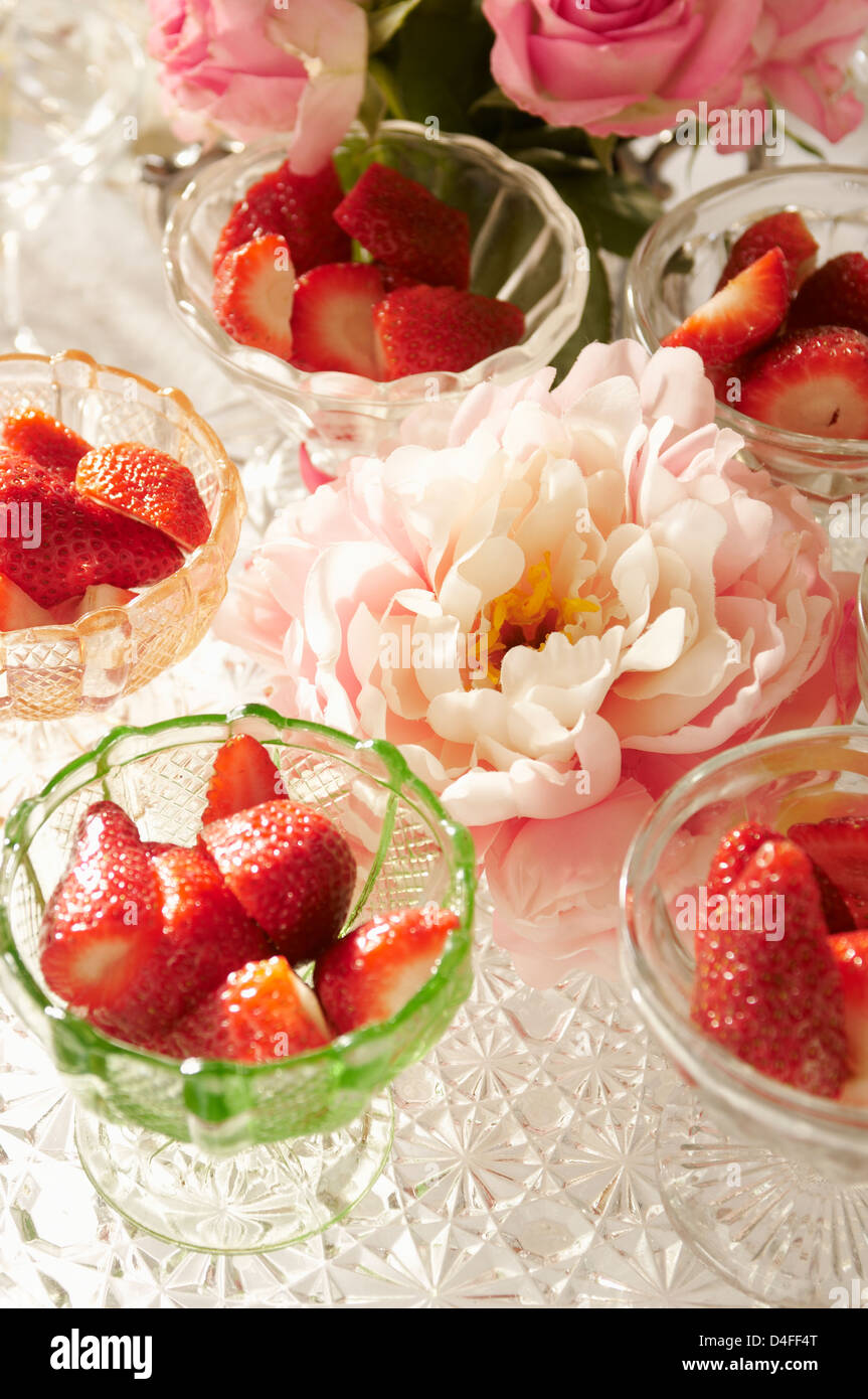 Bocce di fragole e fiori sul tavolo Foto Stock