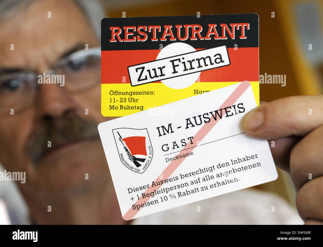 Willi Gau mostra ospiti permanenti' carte sconto progettato come "ID IM-cards" (IM=inofficial agente) presso il recentemente aperto il ristorante "Zur Firma' a Berlino il quartiere di Lichtenberg, Germania, 29 luglio 2008. 'Zur Firma' ha scelto ex RDT per la sicurezza di stato "Servizio tasi' come la sua 'otto'. Il ristorante serve tedesco orientale 'specialities' ed è situato nel "Normannenstrasse', non lontano dal fo Foto Stock