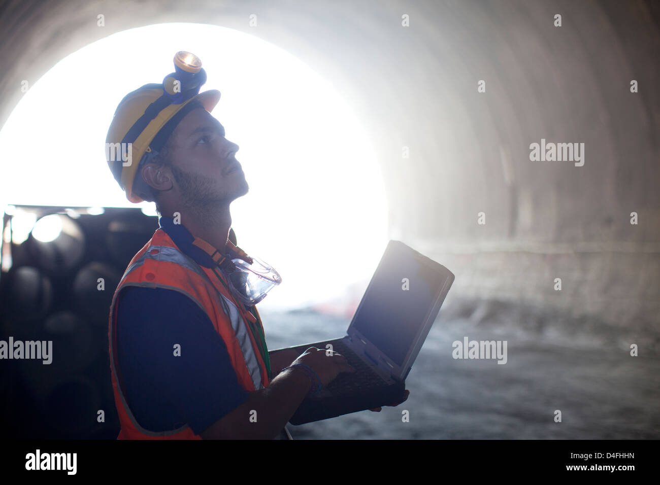 Lavoratore utilizzando laptop nel tunnel Foto Stock