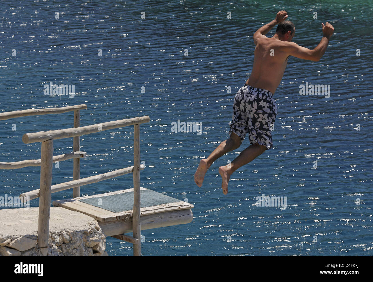 Un giovane uomo salta fuori una piattaforma subacquea costruito nella roccia presso la scogliera-rigato baia del Porto Roxa vicino a Agios Leon sull'isola di Zante, Grecia, 23 giugno 2008. Foto: Uwe Anspach Foto Stock