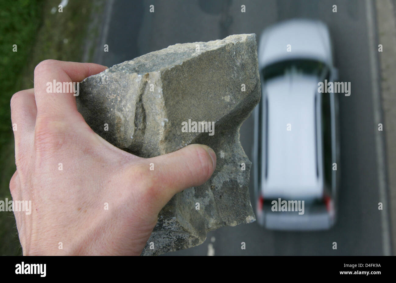 Foto simbolico - un uomo sta per gettare un sasso su una macchina che passa al di sotto di un incrocio autostradale vicino a Osterode, Germania, 12 giugno 2008. Ulteriori e più gravi incidenti causati da ignoti che lanciano pietre da incroci autostradali sono stati registrati negli ultimi anni. Foto: Frank può Foto Stock