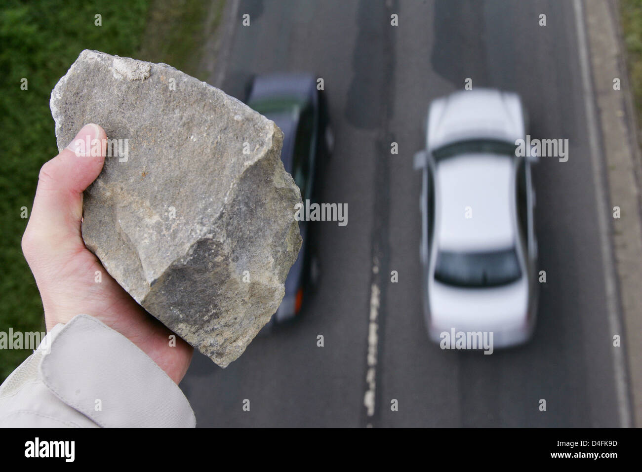 Foto simbolico - un uomo sta per gettare un sasso su una macchina che passa al di sotto di un incrocio autostradale vicino a Osterode, Germania, 12 giugno 2008. Ulteriori e più gravi incidenti causati da ignoti che lanciano pietre da incroci autostradali sono stati registrati negli ultimi anni. Foto: Frank può Foto Stock