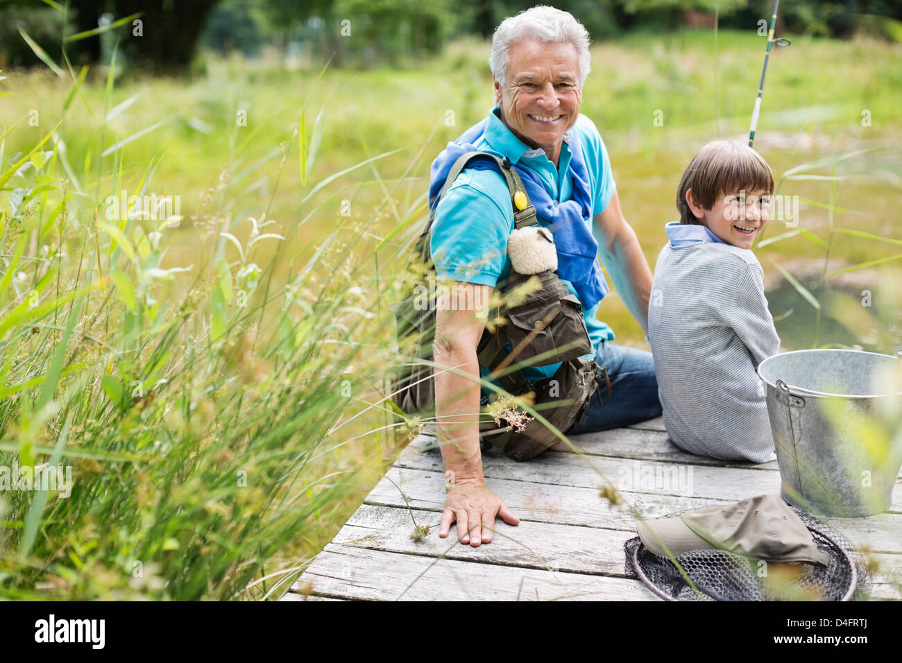 Uomo di pesca con il nipote sul dock in legno Foto Stock