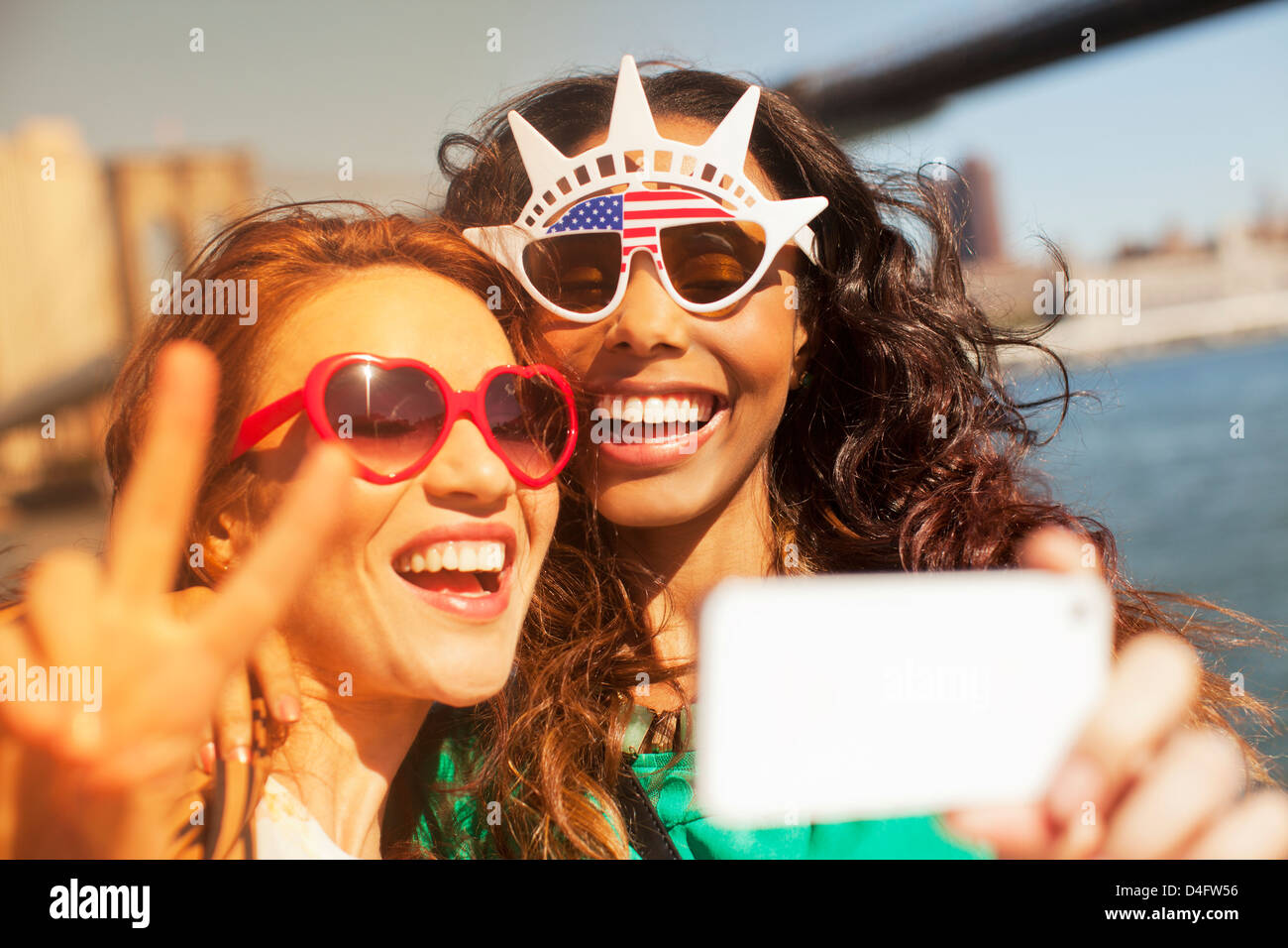 Le donne che prendono una foto di loro stessi in novità di occhiali da sole Foto Stock