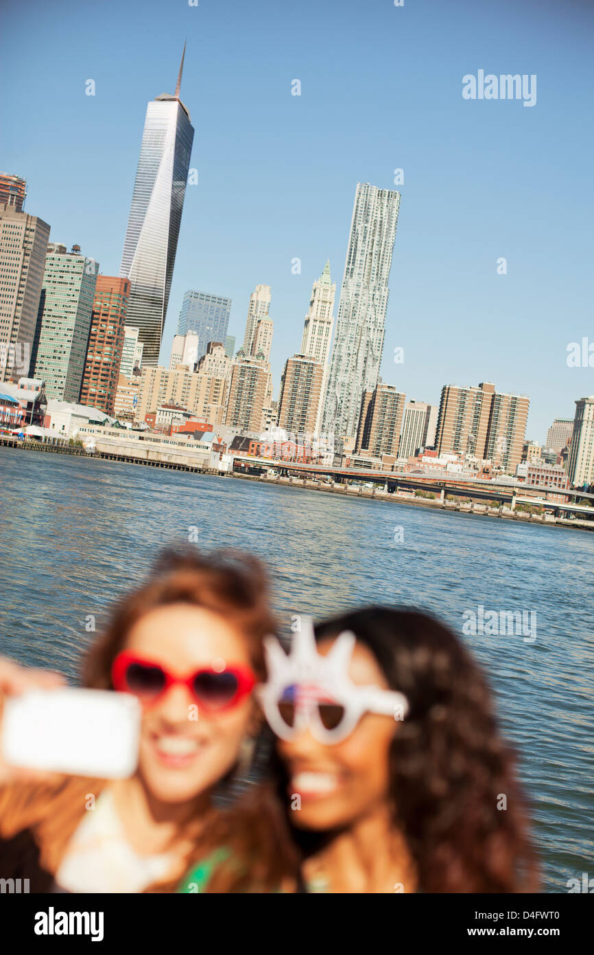 Le donne in novità di occhiali da sole di scattare una foto dal paesaggio urbano della città Foto Stock