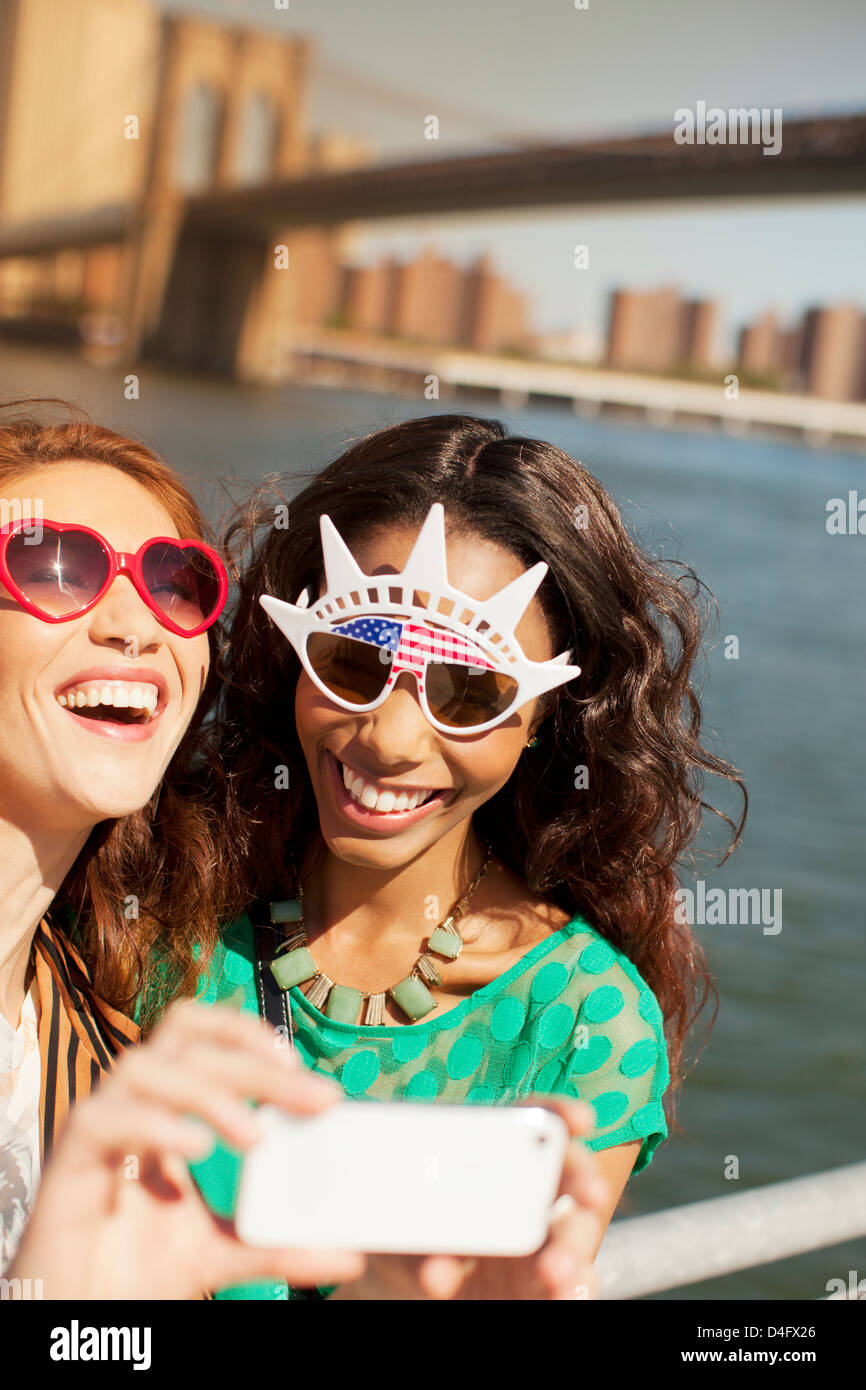 Le donne in novità di occhiali da sole di scattare una foto dal paesaggio urbano della città Foto Stock