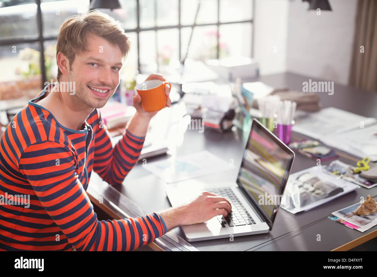 Uomo con notebook con la tazza di caffè Foto Stock