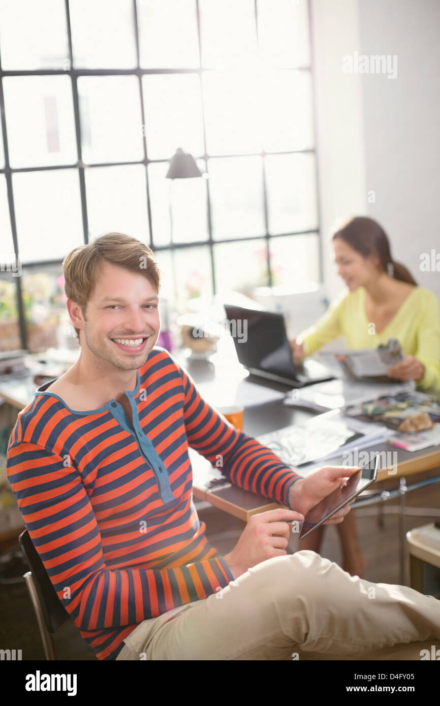 Uomo sorridente con tavoletta digitale Foto Stock