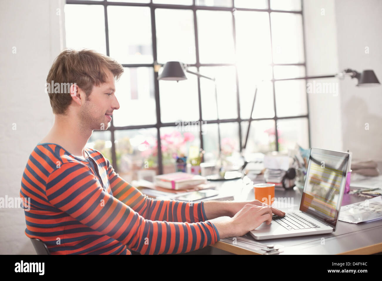 Uomo con notebook alla scrivania Foto Stock