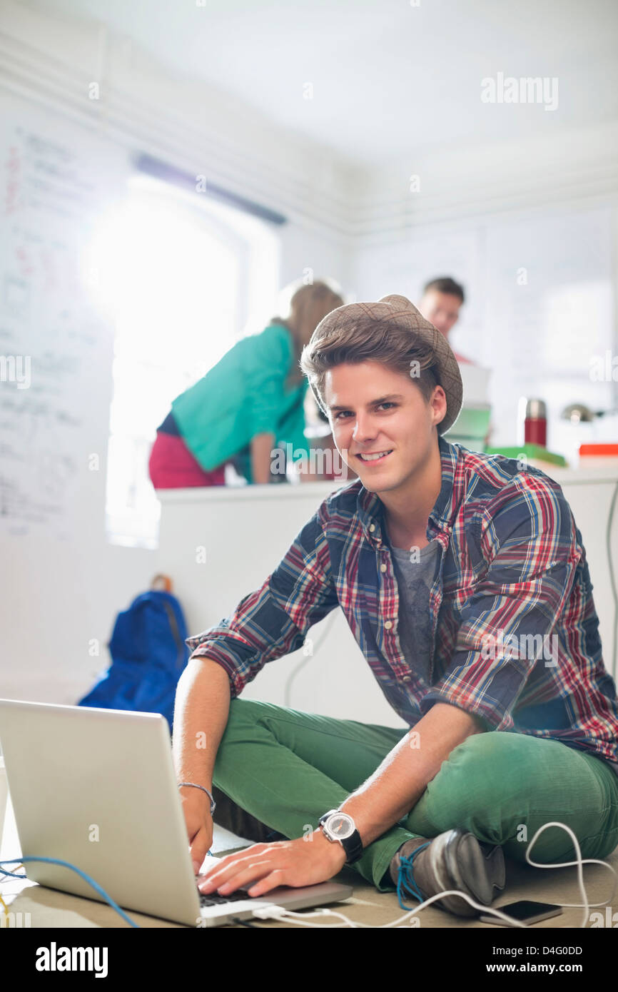 Uomo d affari con computer portatile sul pavimento in ufficio Foto Stock