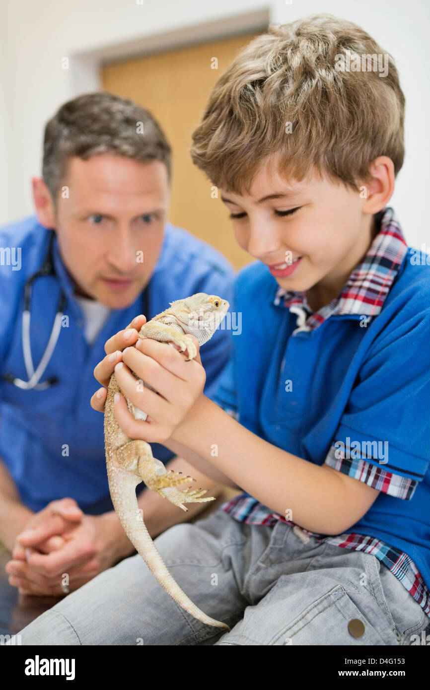 Veterinario e proprietario esaminando lizard in vet chirurgia dell Foto Stock