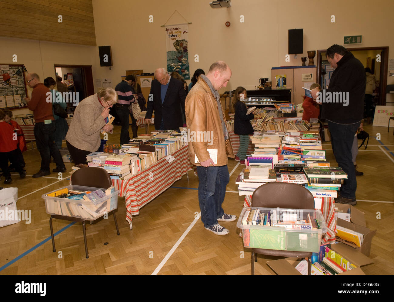 Persone che stanno curiosando libri a una carità prenota giorno in aiuto di un cuore la carità Foto Stock